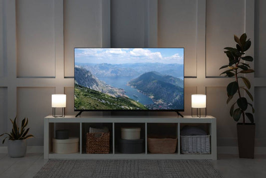 A large TV in a living room, with mountains on the screen.