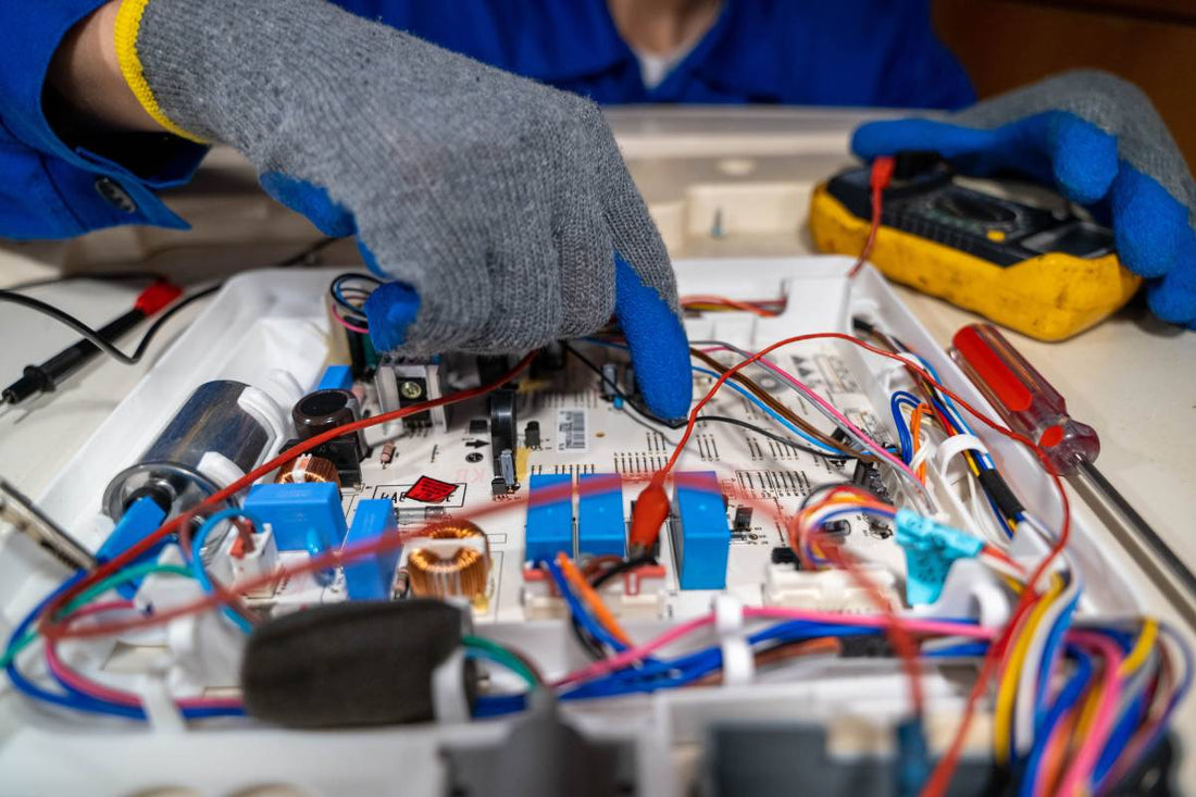 Technician repairs electronic circuit board in workshop during daylight hours