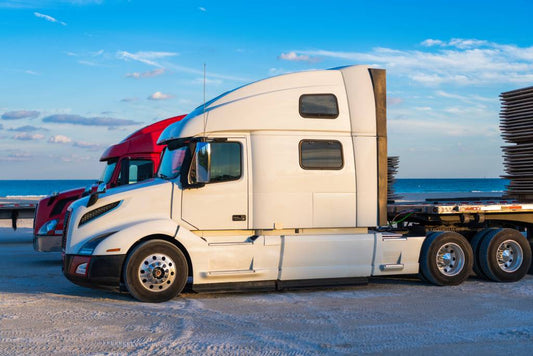 Two freightliner trucks lined up, one white and one red